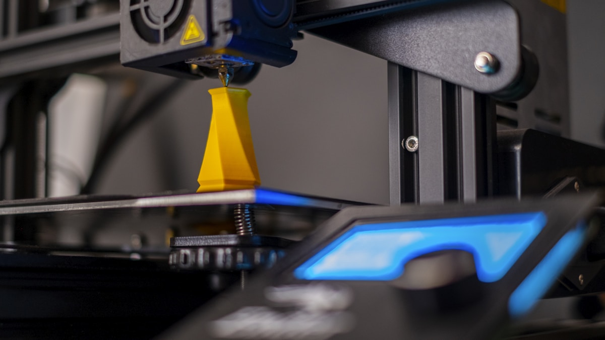 3Dプリンタが黄色い造形物をプリントしている様子