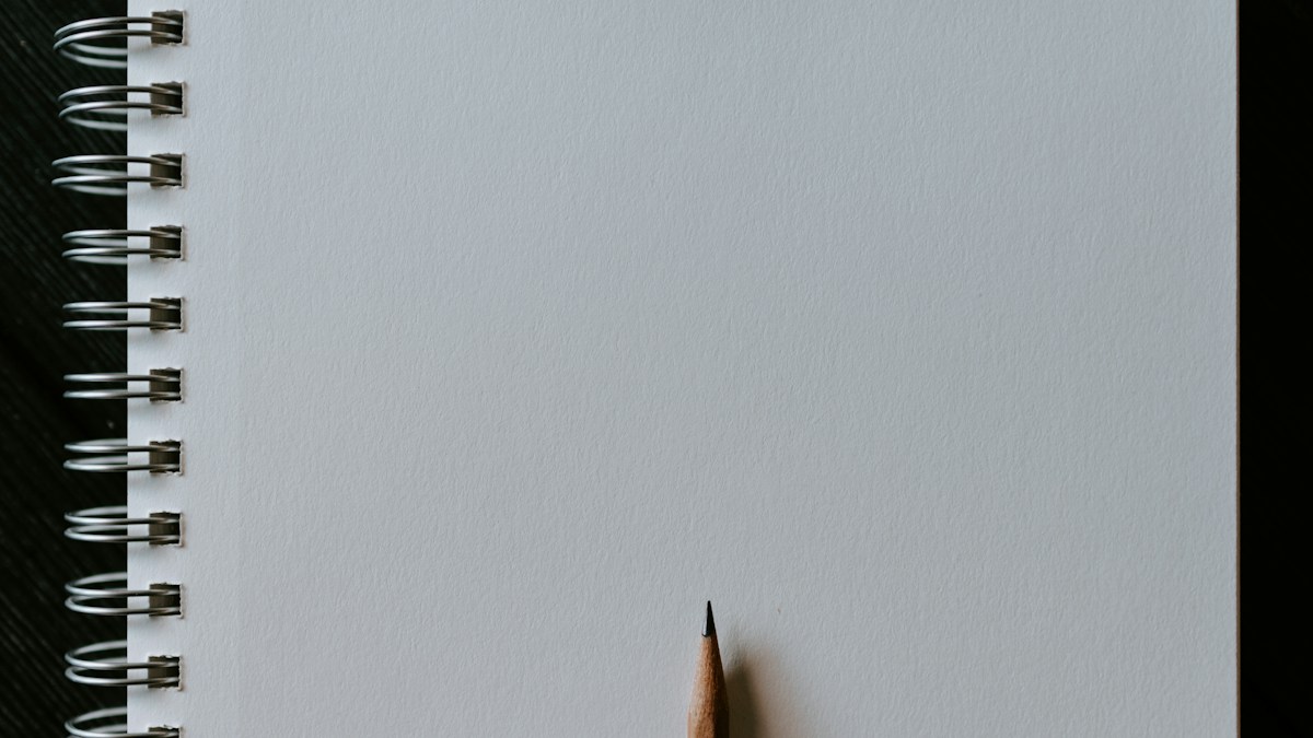 白いスケッチブックの上に置かれた鉛筆(Sketch機能の暗喩)